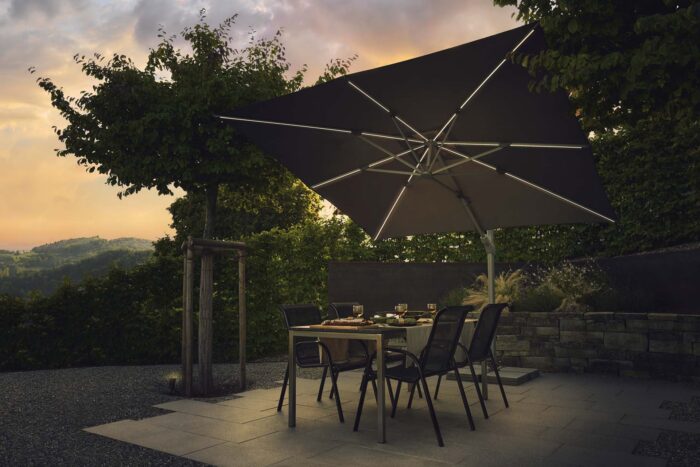 parasol déporté LED varioflex solar stone grey 057 sur une terrasse allumé