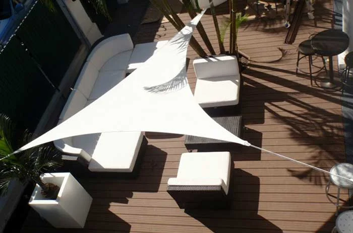 Petite voile d’ombrage triangle installée sur un balcon urbain.