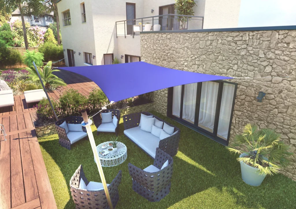 Voile d’ombrage rectangle grise fixée sur une façade de maison moderne.