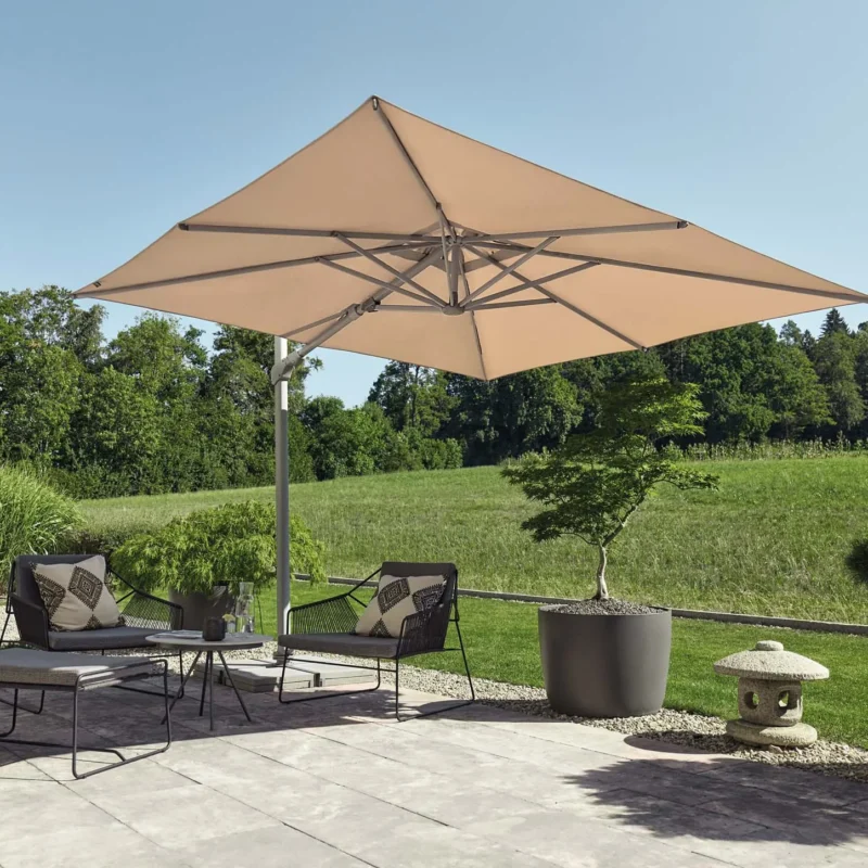 Mise en situation d'un parasol déporté inclinable latéralement Varioflex écru sur une terrasse en bois moderne.