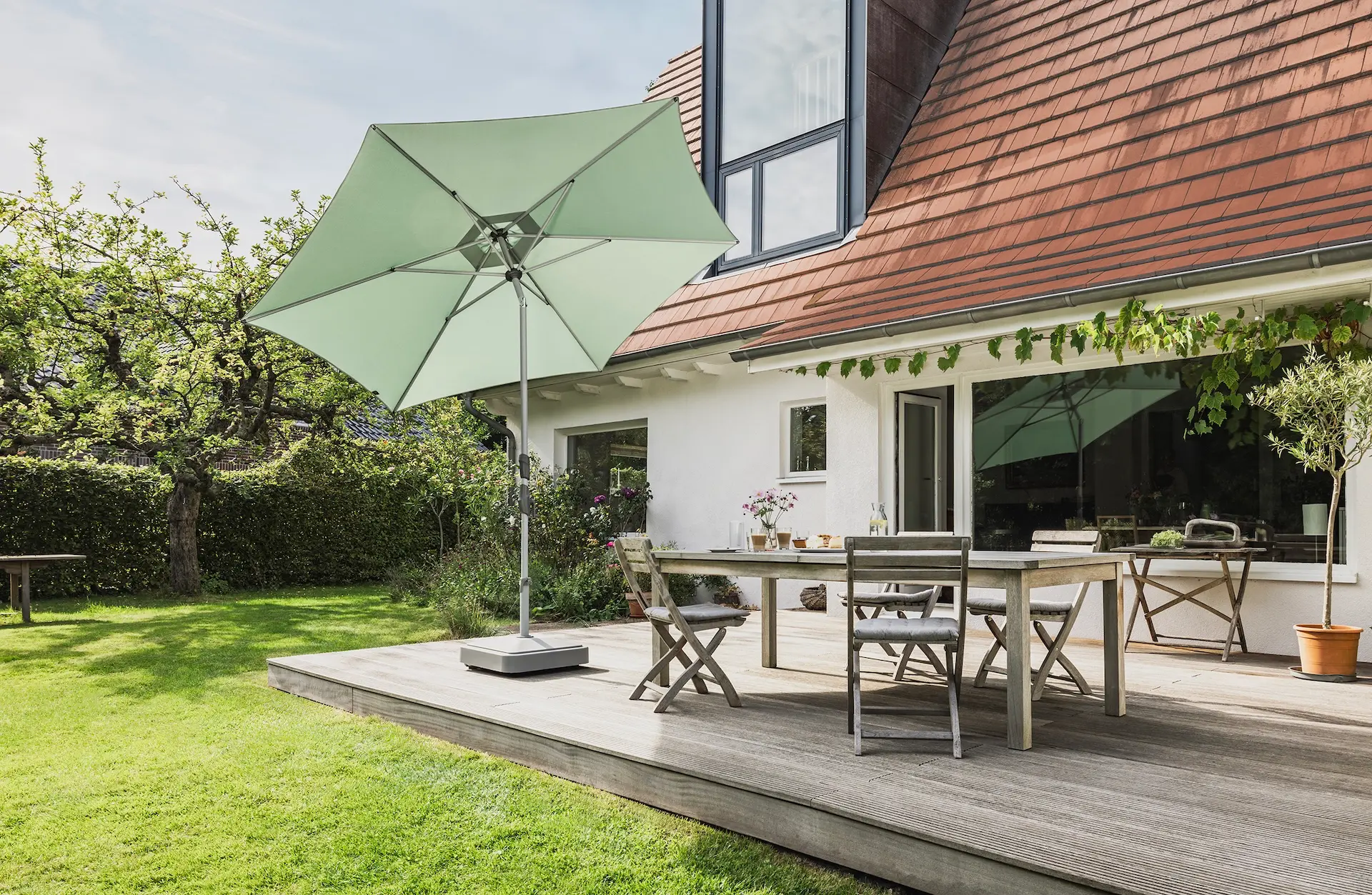 Parasol design toit plat Suncomfort Slide coloris 023 frost green en situation.