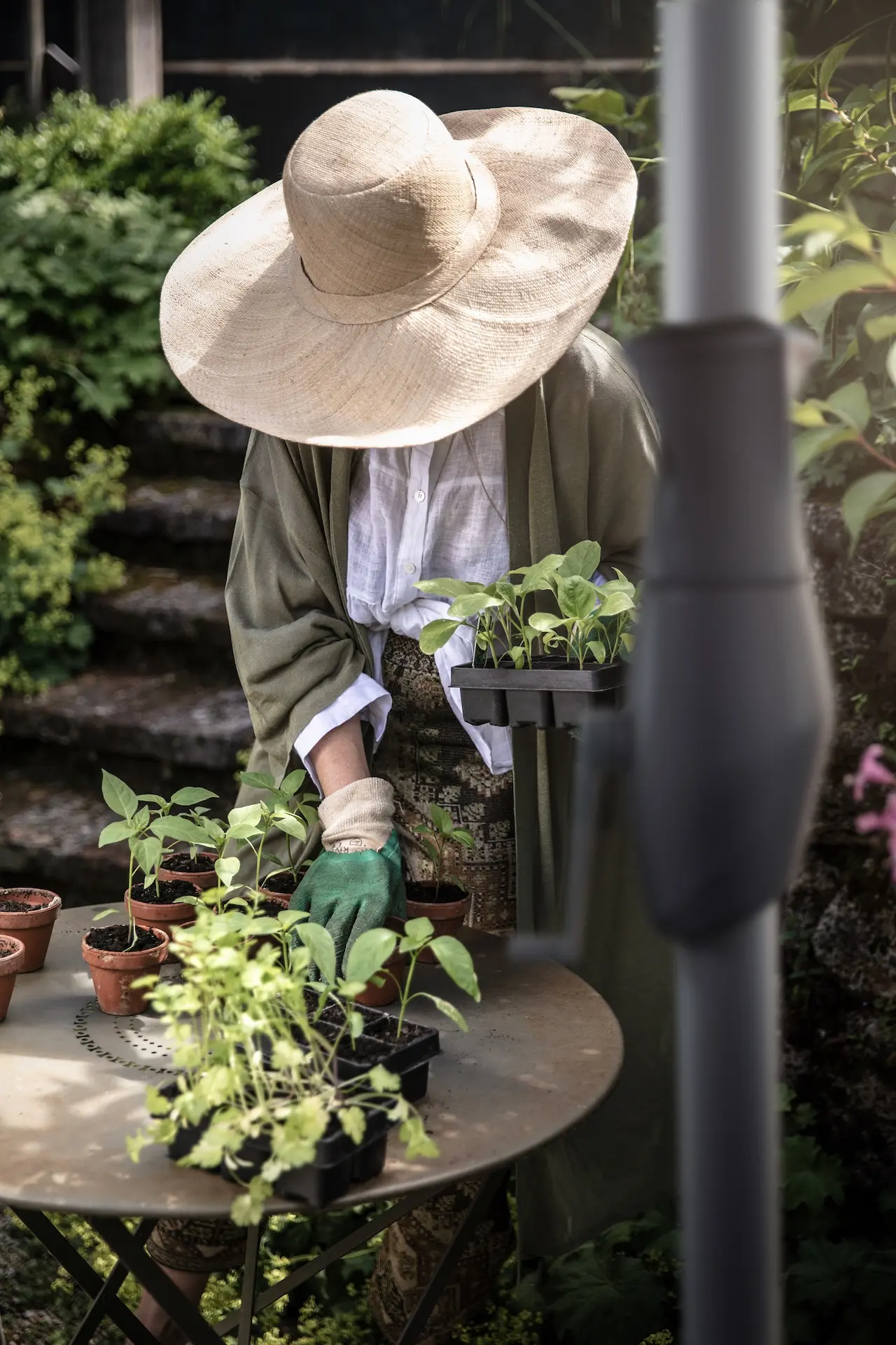 Gros plan sur le mât et la manivelle d'un parasol Glatz ALU-TWIST dans un jardin