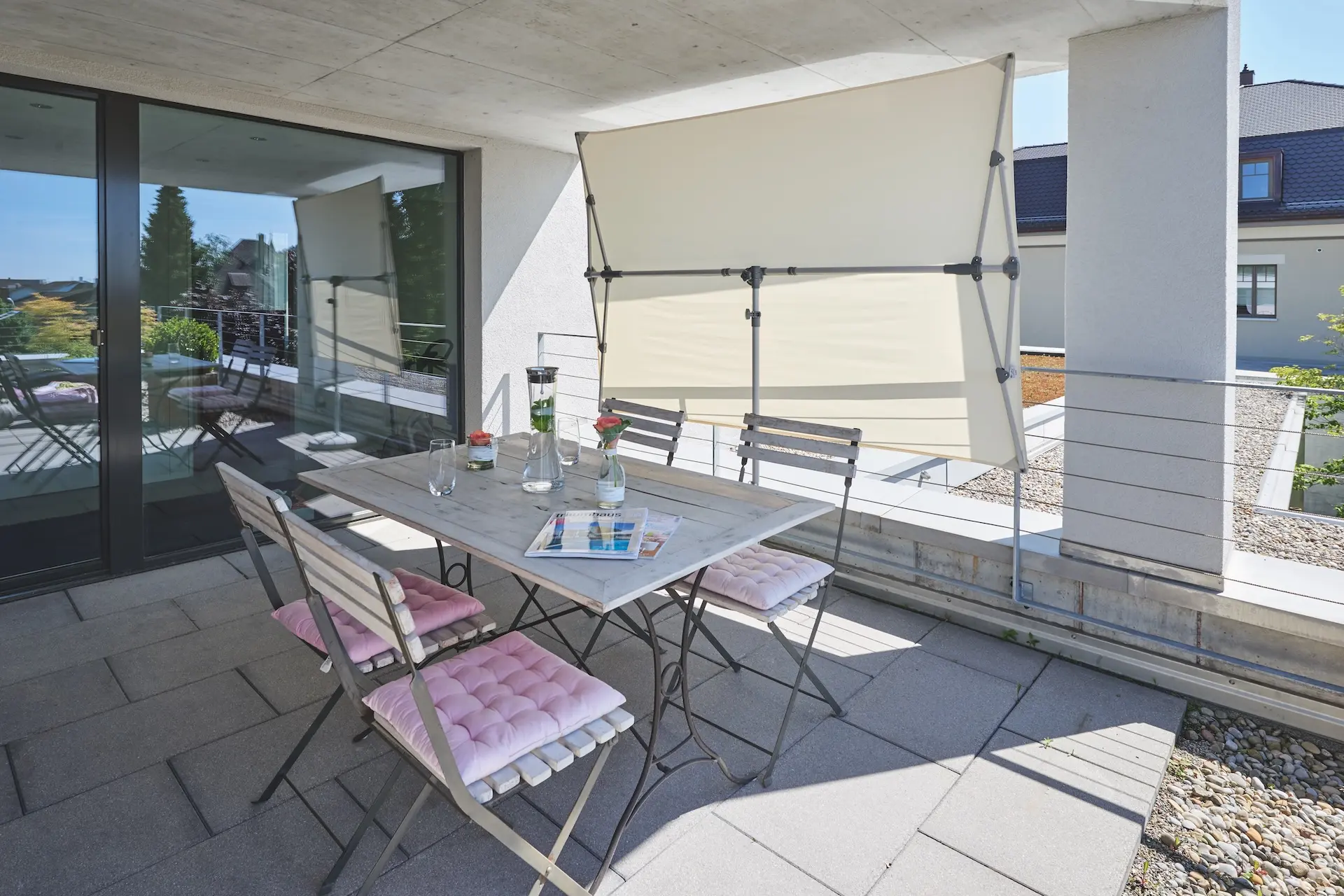 Parasol vertical de balcon inclinable Flex Roof utilisé comme brise-vue sur une terrasse.