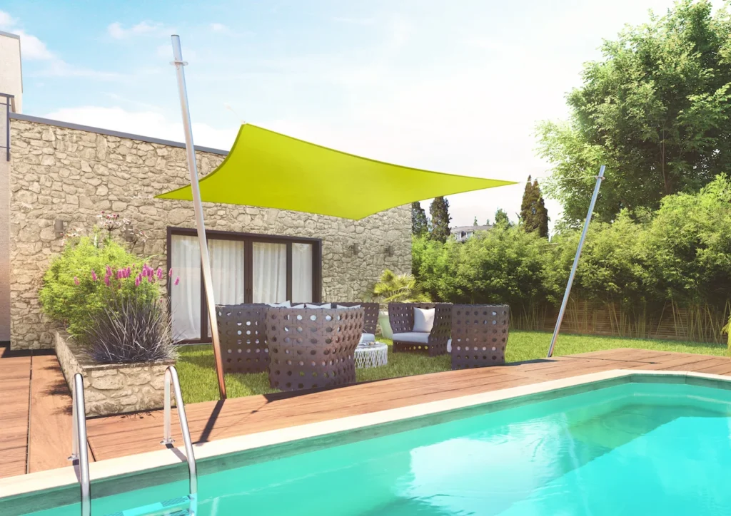 Voile d'ombrage carrée crème installée au-dessus d'un salon de jardin.