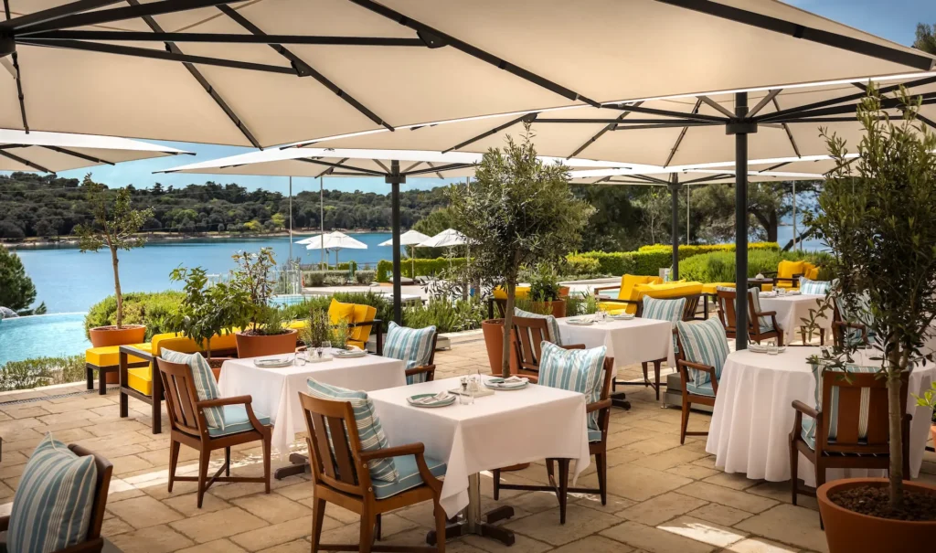 Grands parasols professionnels sur une terrasse de restaurant chic en bord de lac.